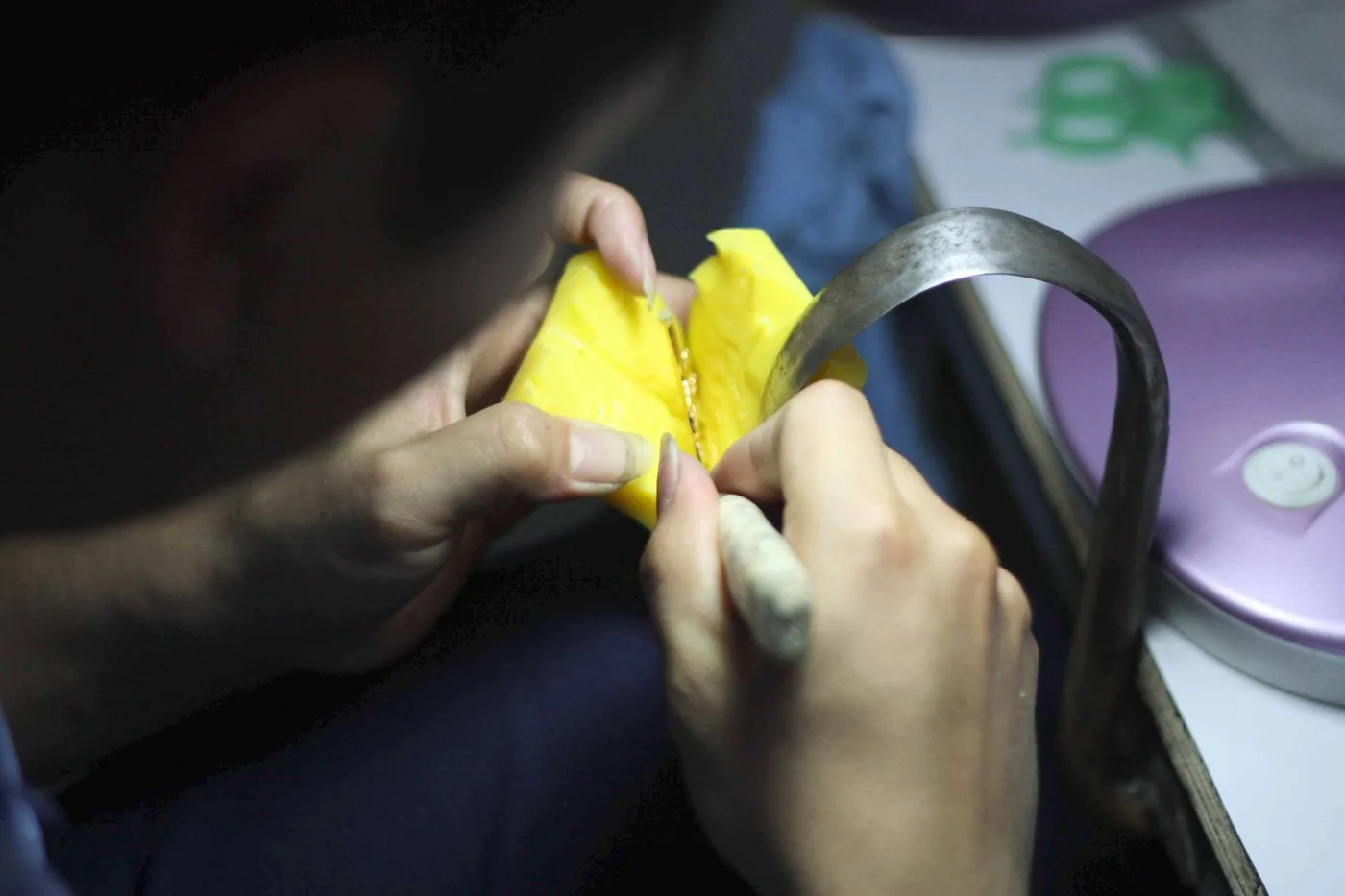 Craftsman refining a wax jewellery model by hand.